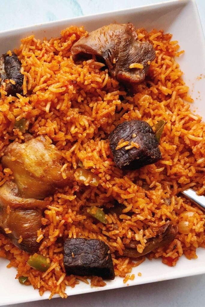 Insanely delicious party-style Nigerian basmati Jollof rice is the only Jollof rice recipe you need. The fusion of basmati rice with tomatoes, peppers, onions, garlic, curry, thyme, bay leaves, and other herbs/spices makes this party Jollof absolutely flavorful and tasty! The best part about making basmati Jollof rice is that it takes no time to cook. Amazingly, you can further cut down on this cooking time by making the sauce or base ahead of time. Call family and friends, let’s gather for this authentic crowd-pleasing party-style Jollof rice recipe! #Jollofrice #Africanfood #Nigerianfood #PartyJollofrice #NigerianJollofrice #BasmatiJollofrice #Jollof