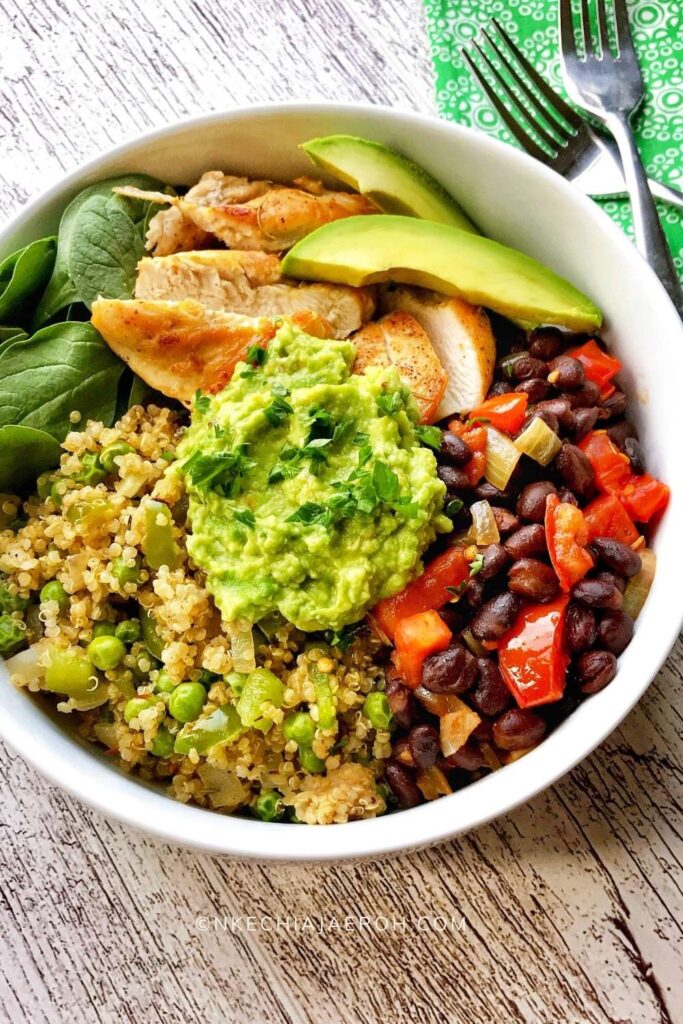 Nutrient-dense + tasty quinoa bowl recipe with black beans is literally the best thing E V E R! Listen, this is about to be your favorite quinoa bowl from now on (I AM NOT KIDDING)! Already cooked quinoa is deliciously sauteed with onions, bell peppers, mixed veggies, and spices. Sauteed black beans, chicken breast, mashed avocado, and fresh baby spinach completes this healthy quinoa bowl recipe! Finally, top this bowl with chopped fresh parsley and avocado slices and enjoy! #quinoarecipe #quinoabowl #blackbeanrecipe #quinoablackbeans #tacobowl