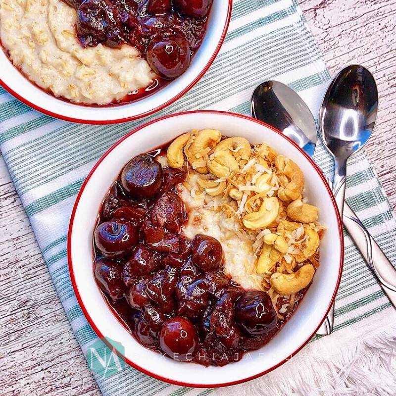 Comforting coconut milk oatmeal porridge with stewed cherry topping