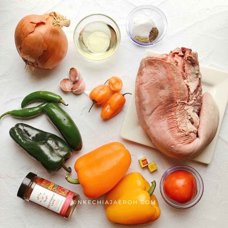 Ingredients for making peppered beef tongue include beef tongue, bell peppers, onions, olive oil, garlic, tomatoes, more peppers and herbs and spices.