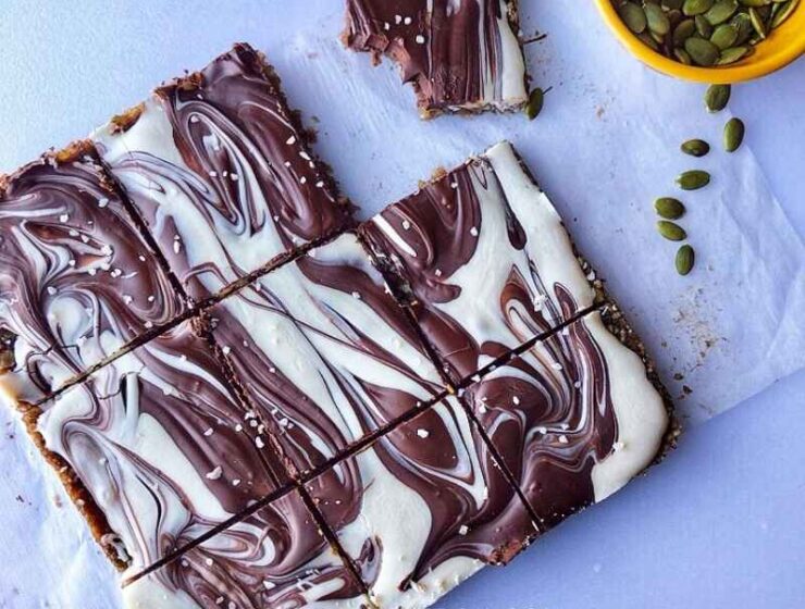 These healthy pumpkin bars made with pumpkin seeds, sunflower seeds, coconut flakes, dates, pink salt, and then topped with a chocolate swirl will make your day. These bars are gluten-free, grain-free, and refined sugar-free, as well as a no-bake! Make sure to make these pumpkin bars during thanksgiving and other occasions! Serve pumpkin (seed) bars as healthy snacks, dessert; make a lot, and freeze the remaining. #Pumpkin #Pumpkinbars #pumpkinseeds #sugarfree #grainfree #glutenfree #pumpkinrecipes