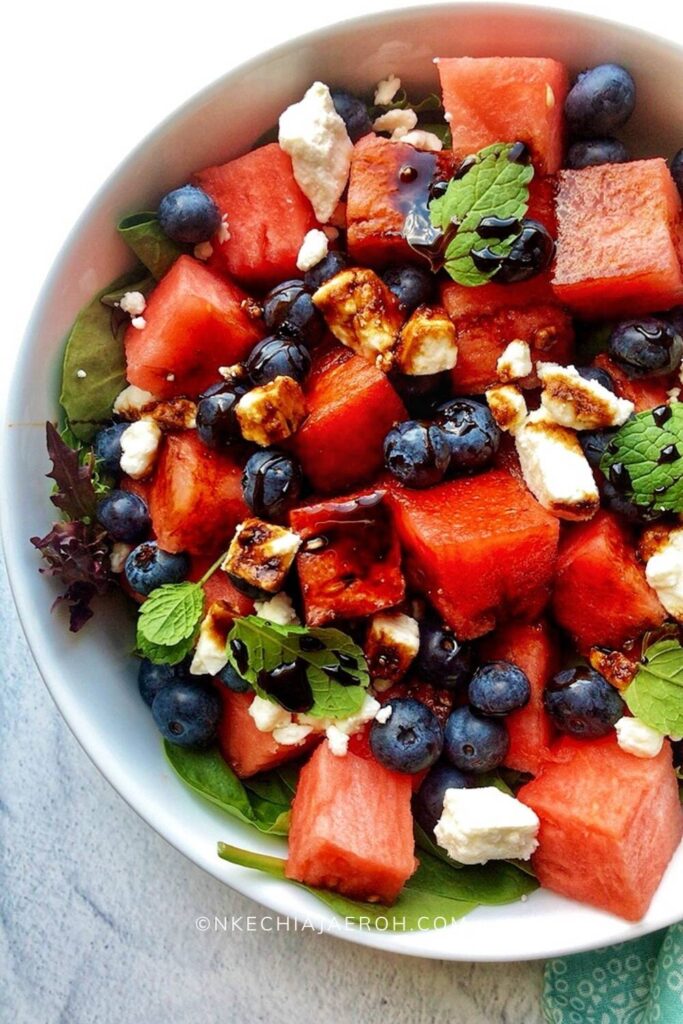 Healthy and fresh blueberry watermelon feta salad recipe with balsamic reduction is refreshingly sweet, savory, and easy to make! The best part about this recipe is that it comes together so fast and is equally cheap with readily available ingredients! This easy watermelon salad needs only four main ingredients โ fresh watermelon, fresh blueberries, feta cheese, and fresh mint leaves. Look no further for an easy nutritious watermelon salad recipe for summer picnics or potlucks. This blueberry watermelon feta salad is equally excellent for Memorial Day or July 4th red, white and blue patriotic recipes! #summersalad #watermelonrecipe #blueberrysalad #redwhiteblue #watermelonfetasalad