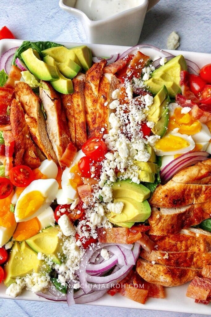 Healthy and delicious keto cobb salad is low-calorie (low-carb, obviously), gluten-free, very tasty, and full of flavors. This salad is made with fresh romaine lettuce, sautéed chicken breast, crispy bacon, hard-boiled eggs, cherry tomatoes, avocado, and crumbled feta cheese. The best thing about this cobb salad is it can be prepped ahead, which means it comes together quickly whenever you want to eat it! This is the low-carb meal prep salad recipe you are looking for; easy, breezy, and tasty! Definitely a must-try! #Cobbsalad #Ketorecipe #ketocobbsalad #healthysalad #lowcarbsalad