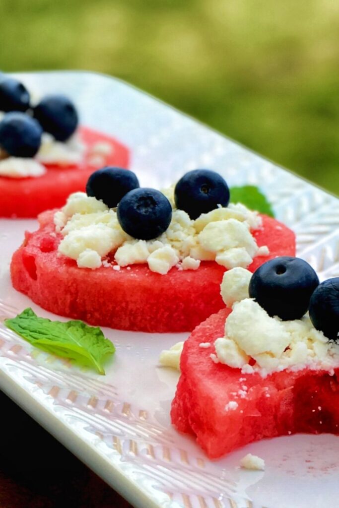 Refreshing and savory watermelon appetizer with feta and blueberry is sweet, salty, revitalizing, and satisfying! This watermelon appetizer with feta and blueberry is the easy red, white and blue color food you need for the 4th of July this year (and any year)! Be warned that these fruity bites can be addictive; at the same time, this is the easiest and quickest red, white, and blue appetizer.
