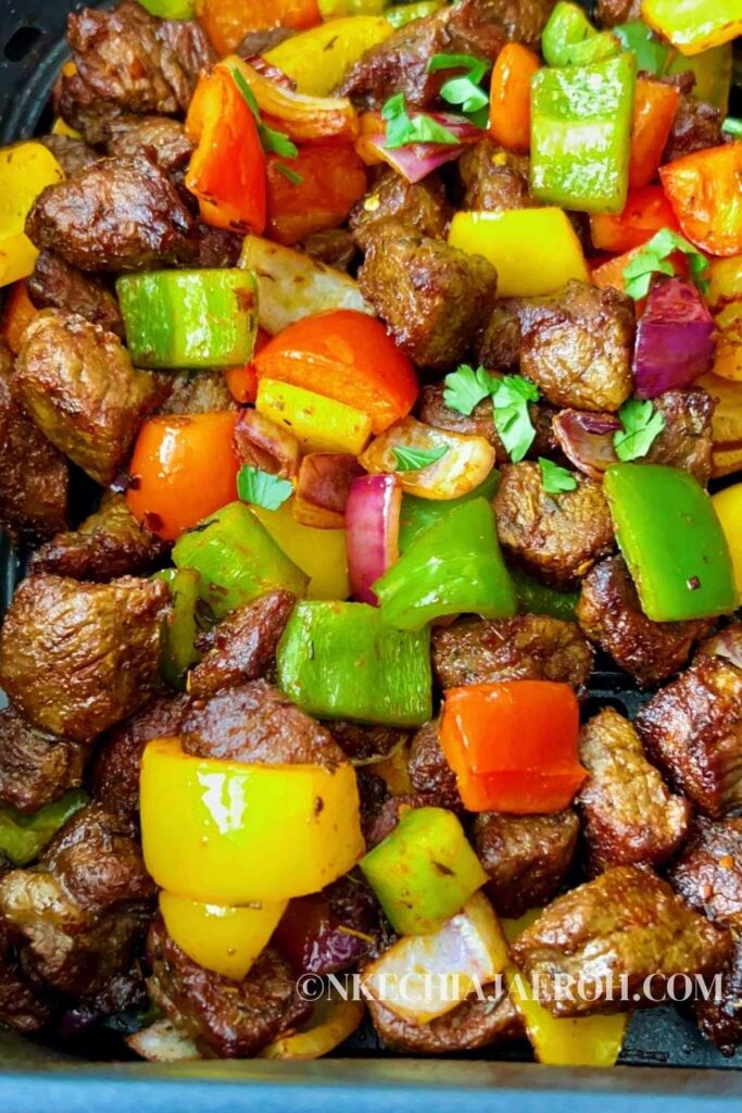A simple recipe of steak bites in an air fryer with bell peppers, onions, herbs, spices, and cooks in less than 15 minutes is the satisfying pick-me-up dish you want on your table today! Air-fried steak bites and peppers are tasty, flavorful, colorful, scrumptious, crispy, shiny, juicy, and just finger-licking good! These steak bites are equally keto, gluten-free, whole30, and sugar-free. Cooking pepper steak, aka steak bites or beef tips, is easy and comes through quickly in an air fryer. I hope you can give these air fryer steak bites a try! #Steakbites #Steak #Peppersteak #Steakrecipe #beefbites #Beeftips #airfryersteak