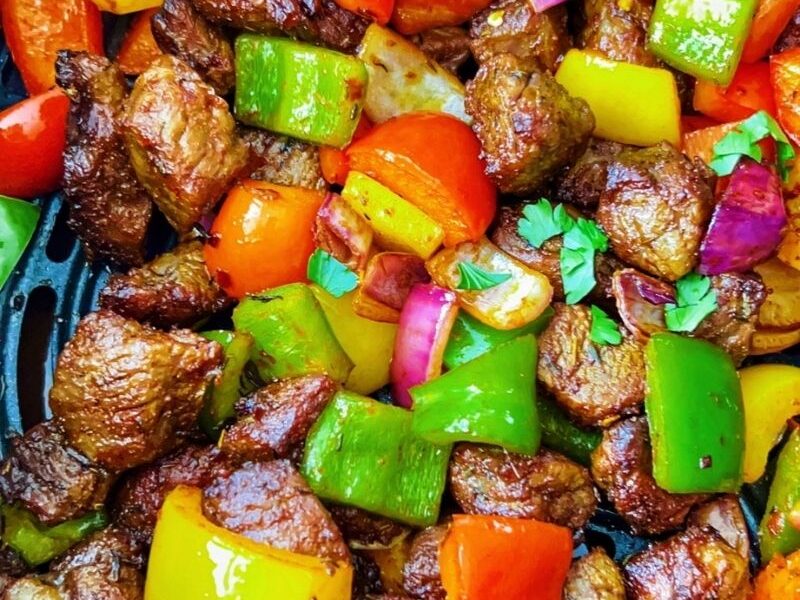 A simple recipe of steak bites in an air fryer with bell peppers, onions, herbs, spices, and cooks in less than 15 minutes is the satisfying pick-me-up dish you want on your table today! Air-fried steak bites and peppers are tasty, flavorful, colorful, scrumptious, crispy, shiny, juicy, and just finger-licking good! These steak bites are equally keto, gluten-free, whole30, and sugar-free. Cooking pepper steak, aka steak bites or beef tips, is easy and comes through quickly in an air fryer. I hope you can give these air fryer steak bites a try! #Steakbites #Steak #Peppersteak #Steakrecipe #beefbites #Beeftips #airfryersteak