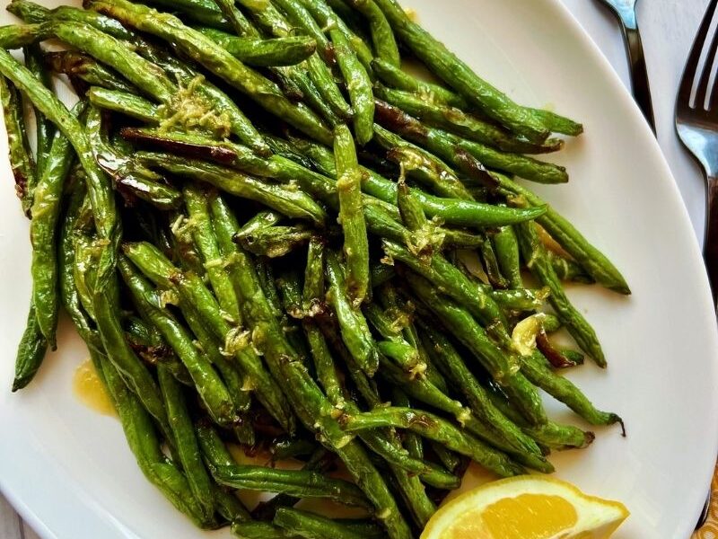 A simple and easy recipe for air fryer green beans with garlic butter sauce requires only a few ingredients; fresh green beans, onions powder, salt, pepper, avocado oil as well a drizzle of garlicky, buttery sauce! Air fried garlic green beans are easy, quick, tender, crisp, deliciously delightful, and perfect with any main dish. P.s. I love it with salmon! This air fryer fried green beans recipe cooks in less than 10 minutes in the air fryer (well, obviously)! But we don't stop there; I take it a little further with my garlic butter sauce. #airfryergreenbeans #greenbeans #garlicsauce #airfryerrecipe