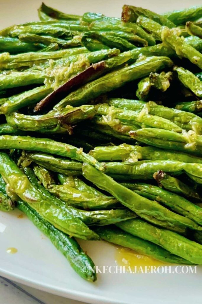A simple and easy recipe for air fryer green beans with garlic butter sauce requires only a few ingredients; fresh green beans, onions powder, salt, pepper, avocado oil as well a drizzle of garlicky, buttery sauce! Air fried garlic green beans are easy, quick, tender, crisp, deliciously delightful, and perfect with any main dish.  #airfryergreenbeans #greenbeans #garlicsauce #airfryerrecipe