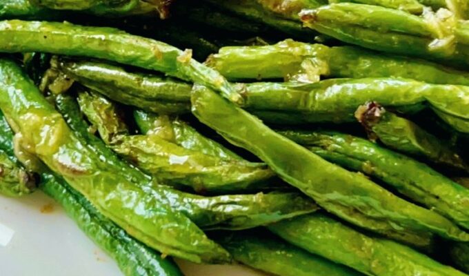 A simple and easy recipe for air fryer green beans with garlic butter sauce requires only a few ingredients; fresh green beans, onions powder, salt, pepper, avocado oil as well a drizzle of garlicky, buttery sauce! Air fried garlic green beans are easy, quick, tender, crisp, deliciously delightful, and perfect with any main dish. P.s. I love it with salmon! This air fryer fried green beans recipe cooks in less than 10 minutes in the air fryer (well, obviously)! But we don't stop there; I take it a little further with my garlic butter sauce. #airfryergreenbeans #greenbeans #garlicsauce #airfryerrecipe