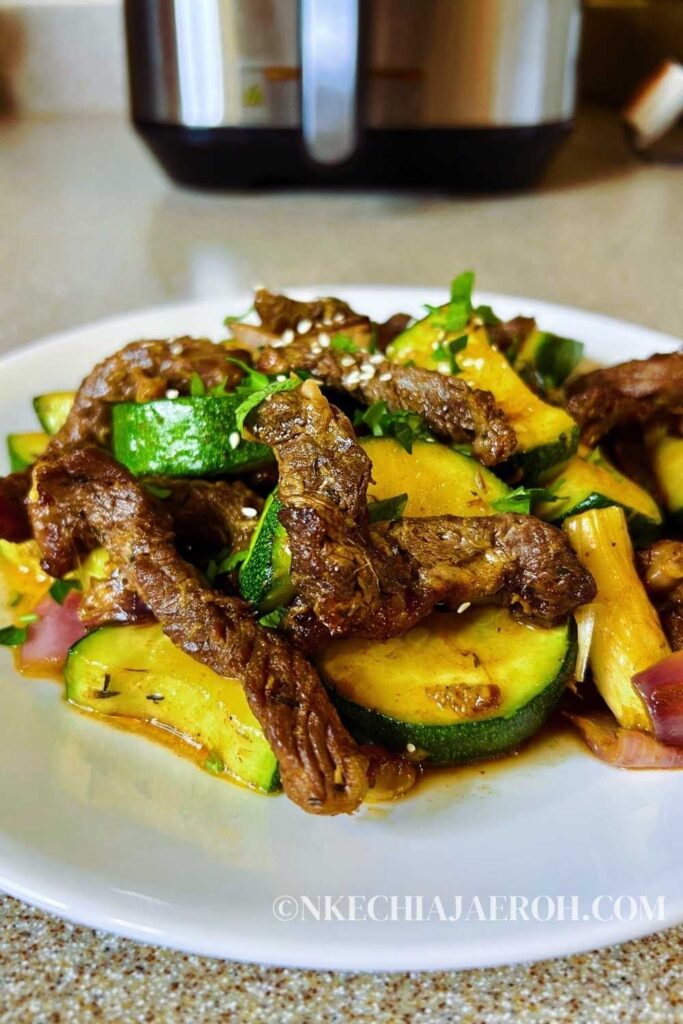 An easy air fryer ribeye steak and zucchini (stir-fry) is a healthy low-carb meal you can easily make in the air fryer. When you air fry a ribeye steak, you end up with a juicy, tasty + satisfying piece of meat. Steak and zucchini stir-fry in the air fryer guarantees you a healthy quick, and easy lunch or dinner. Air-fried ribeye steak and zucchini meal is gluten-free, dairy-free, whole30, low-carb, and keto. #stea #airfryersteak #lowcarb #zucchini 