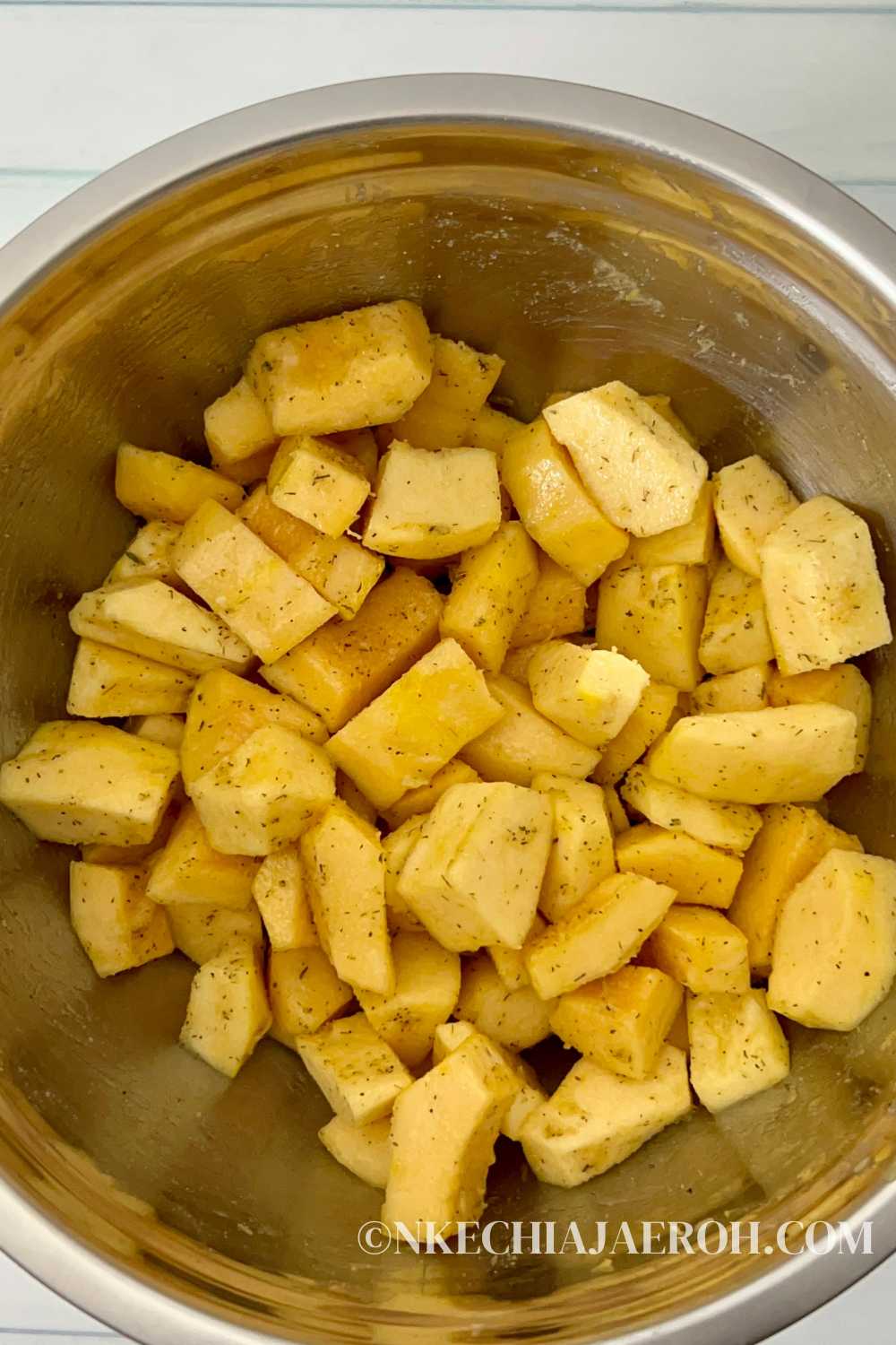 Put your acorn squash cubes into a bowl and drizzle with olive oil and seasonings. Stir it together with a spatula to coat evenly.