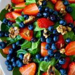 Super healthy and easy-to-make strawberry blueberry spinach salad, aka berry spinach salad with lime olive oil vinaigrette, is loaded with nutritious antioxidants, vitamins, and minerals. Amazingly this spinach and berry salad calls for only a few ingredients - spinach, strawberries, blueberries, walnuts, and a simple lime olive oil vinaigrette! This strawberry blueberry spinach is low-carb, gluten-free, vegan, and easily customizable. #Salad #Spinachsalad #healthysalad #Strawberrysalad #detoxsalad #vegan #lowcarb