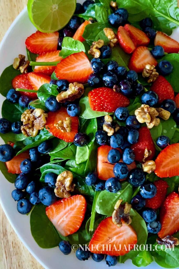 Super healthy and easy-to-make strawberry blueberry spinach salad, aka berry spinach salad with lime olive oil vinaigrette, is loaded with nutritious antioxidants, vitamins, and minerals. Amazingly this spinach and berry salad calls for only a few ingredients - spinach, strawberries, blueberries, walnuts, and a simple lime olive oil vinaigrette! This strawberry blueberry spinach is low-carb, gluten-free, vegan, and easily customizable. #Salad #Spinachsalad #healthysalad #Strawberrysalad #detoxsalad #vegan #lowcarb