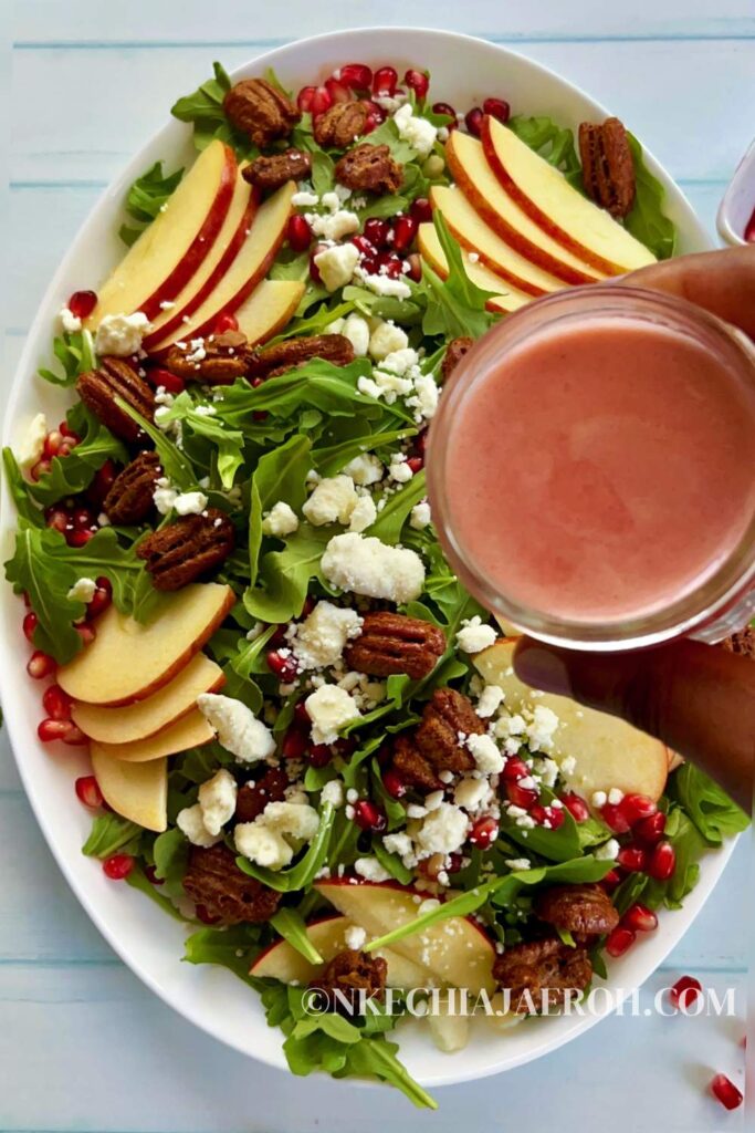 Healthy pomegranate arugula salad with apples and pecans is easy to make, pretty, and perfect for any occasion! My pomegranate salad bursts with delicious flavors from the slightly spiced arugula, sweet and crisp apples, and crunchy pecans. This easy salad is bejeweled with fresh pomegranate seeds or arils and finished with pomegranate salad dressing. This would make an enviable summertime salad recipe as well!  #Pomegranatesalad #arugulasalad #pomegranate #salad