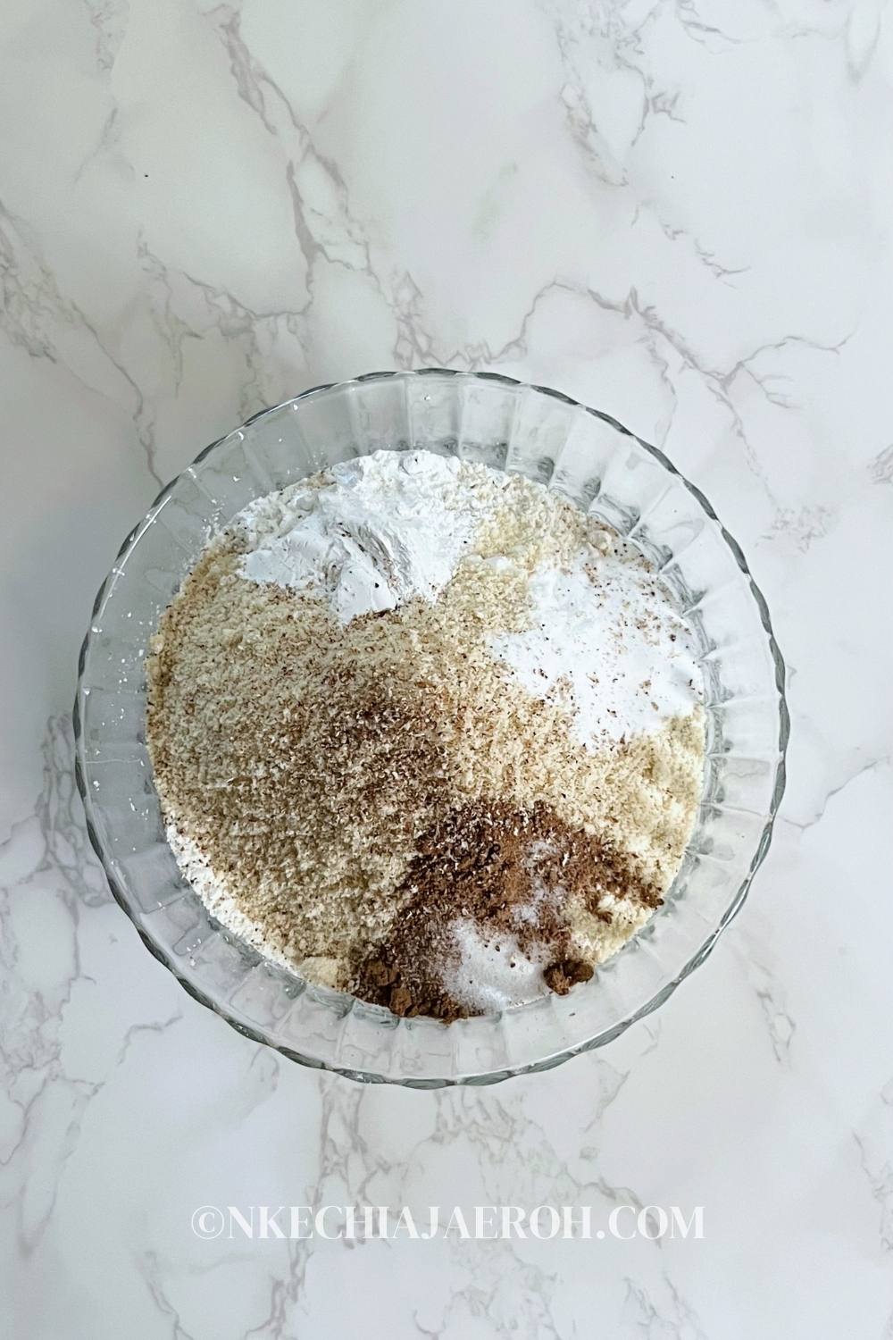 Add all the dry ingredients (all-purpose flour, almond flour, baking powder, baking soda, pumpkin spice, salt, cinnamon, and freshly grated nutmeg) into a bowl. Then, use a fork, mix, and set aside.