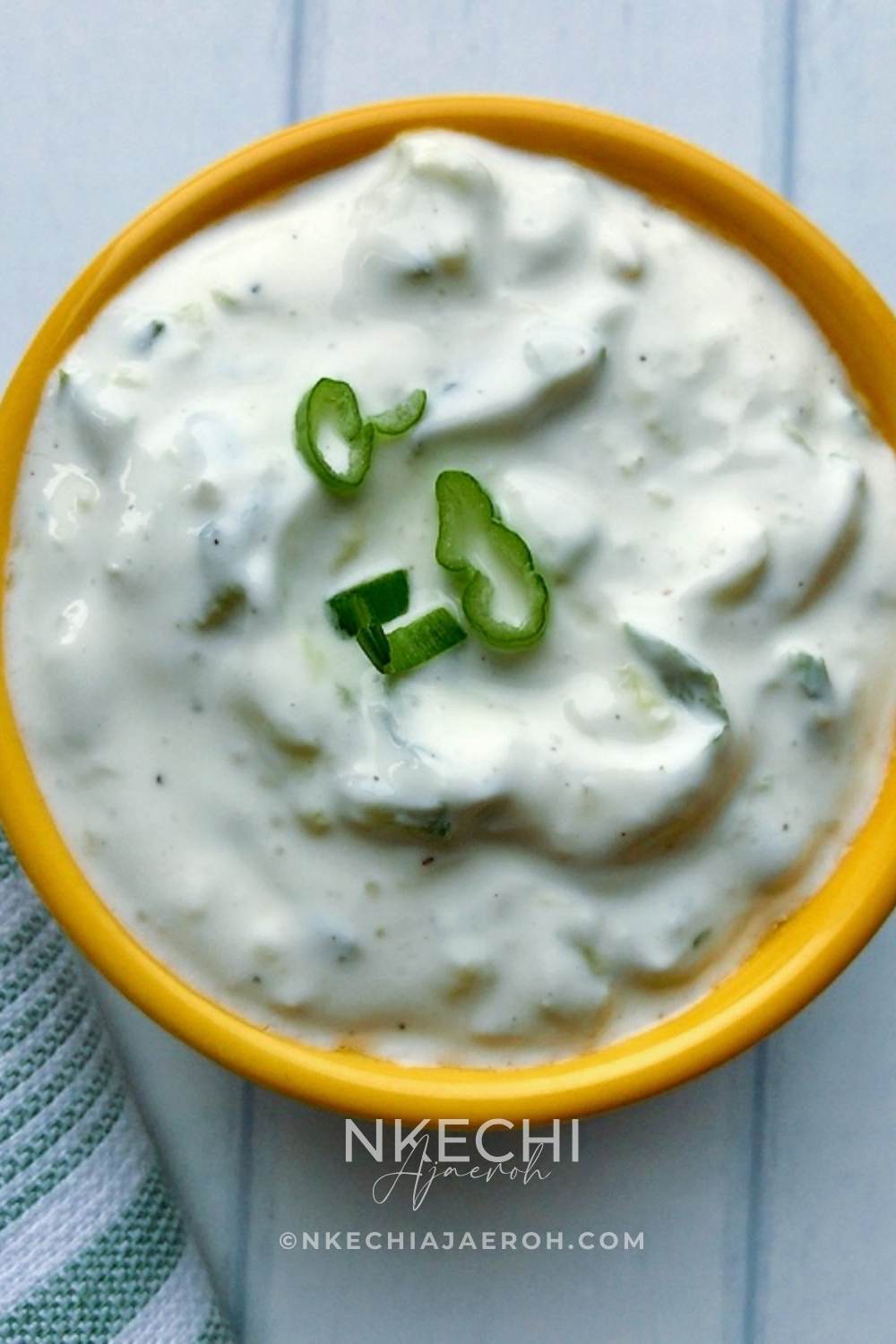 Make your yogurt-cucumber dip with the fitters cook. Wash your English cucumber and dry it off with a paper towel. Grate it with your box grater, then season with half a teaspoon of salt. Let sit for at least 5 minutes, then squeeze out the water. You can then add the cucumber to a clean bowl with the yogurt, sour cream, pepper, and garlic. Mix it well and taste, adjusting the flavors if needed, then serve with the chicken fritters. 