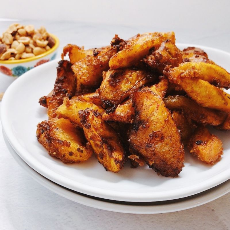 Kelewele or Aloco (Alloco) is a Ghanaian spiced fried plantain recipe. This richly flavored fried snack is very popular in the streets of Ghana and typically pairs with groundnuts (peanuts). The combination of sweet, ripe plantains with fresh herbs and spices such as fresh onions, ginger, and other dry traditional spices makes this dish unique and unforgettable. If you like fried plantains, you will love these Ghanaian spicy fried plantains - kelewele. What does Kelewele (Ghanaian Spicy Fried Plantains) Taste Like? What does Kelewele mean? In English, kelewele means “hot plantain crisps.” It is simply a spicy or spiced fried ripe plantains. These Ghanaian spicy fried plantains are gluten-free, dairy-free, and vegan.
