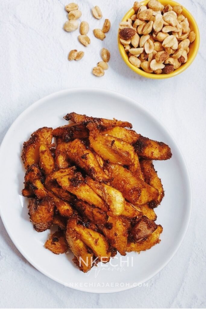Kelewele or Aloco (Alloco) is a Ghanaian spiced fried plantain recipe. This richly flavored fried snack is very popular in the streets of Ghana and typically pairs with groundnuts (peanuts). The combination of sweet, ripe plantains with fresh herbs and spices such as fresh onions, ginger, and other dry traditional spices makes this dish unique and unforgettable. If you like fried plantains, you will love these Ghanaian spicy fried plantains - kelewele. What does Kelewele  (Ghanaian Spicy Fried Plantains) Taste Like? What does Kelewele mean? In English, kelewele means “hot plantain crisps.” It is simply a spicy or spiced fried ripe plantains. These Ghanaian spicy fried plantains are gluten-free, dairy-free, and vegan.