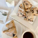 There are scones, and then there are these super sweet + nutritious blueberry scones made with frozen ripe blueberries. Wishing you could just eat those blueberry scones you saw at the bakery? Let me show you how to make your own with the sweetest and most nutritious blueberry scones recipe EVER! Made with frozen berries, you won’t have to wait for berry season to enjoy these. If you have ever had a scone before you know that you typically smash butter, cream, or fruit sauce or preserve on them but not this one! These melt-in-your-mouth blueberry scones are super sweet, rich, and decadent, and no extra accompaniment is needed. You will never get any scones here on the streets that are better than these.