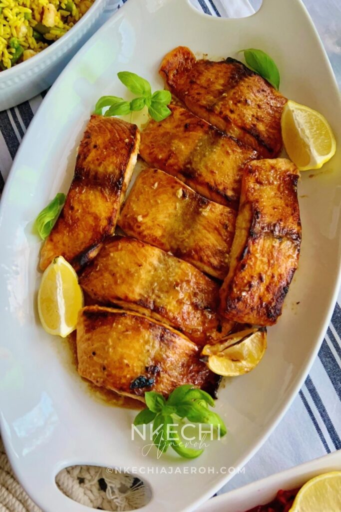 This simple oven-baked buttery honey mustard salmon recipe is first seasoned with the honey mustard sauce and then baked to perfection. These salmon is tasty, flaky, buttery and not to mention that they are super easy to make and requires no expertise!
I have several salmon recipes here on the blog including, air fryer salmon and pan seared salmon. However, these oven-baked buttery honey mustard salmon is our favorite. The butter, honey and mustard using in making this recipe makes it unique. These will be your favorite too! This oven-baked salmon recipe is ideal for meal prepping and can be versatile and great for special occasions.