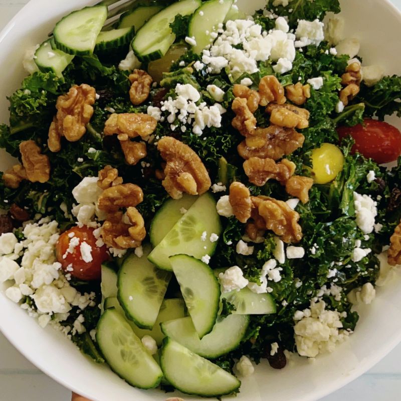 The only easy kale salad you need! This kale feta salad recipe is packed with walnuts, cucumbers, and tomatoes. If you love kale, then you will enjoy this healthy salad, but if you are skeptical about kale, then this will change your mind. Though this is a vegetarian salad, you can still add meat or fish of your choice to make it more filling. This salad comes together in minutes, and if you know you need to eat more veggies but are tired of the same old stuff, this one is going to make you love salad. It’s such a rewarding bowl of goodness, and I’m here to help you get it on your table tonight! What are the ingredients in kale salad? Can you eat raw kale as a salad? What's in Chick-fil-A's kale salad? How do you get the bitterness out of kale salad?