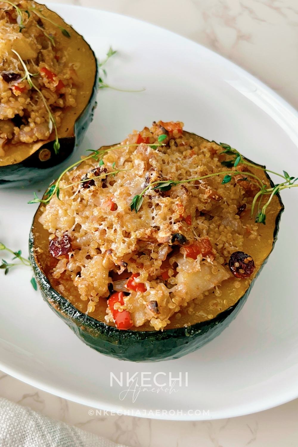 This Healthy Quinoa-Stuffed Acorn Squash is packed with wholesome quinoa, spinach, cranberries, and herbs. A delicious, gluten-free vegetarian main or side dish for your cozy fall meals or Thanksgiving table! Quinoa-stuffed acorn squash halves on a baking tray with fresh herbs. Roasted acorn squash filled with quinoa, cranberries, and spinach. Healthy vegetarian acorn squash stuffed with quinoa and nuts. Quinoa and vegetable filling being spooned into roasted acorn squash. Beautifully roasted acorn squash halves served for Thanksgiving dinner.