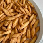 Nigerian chin chin is a popular West African snack known for its crunchy texture, buttery flavor, and lightly sweet taste. Made from a simple dough of flour, butter, sugar, eggs, and nutmeg, chin chin is rolled, cut into small pieces, and fried until golden and crisp. This classic snack is a staple at holidays, birthdays, weddings, and family gatherings, and it’s just as common to find it sold as street food. Chin chin stays crunchy for days and is easy to make in large batches, which makes it perfect for sharing and gifting.