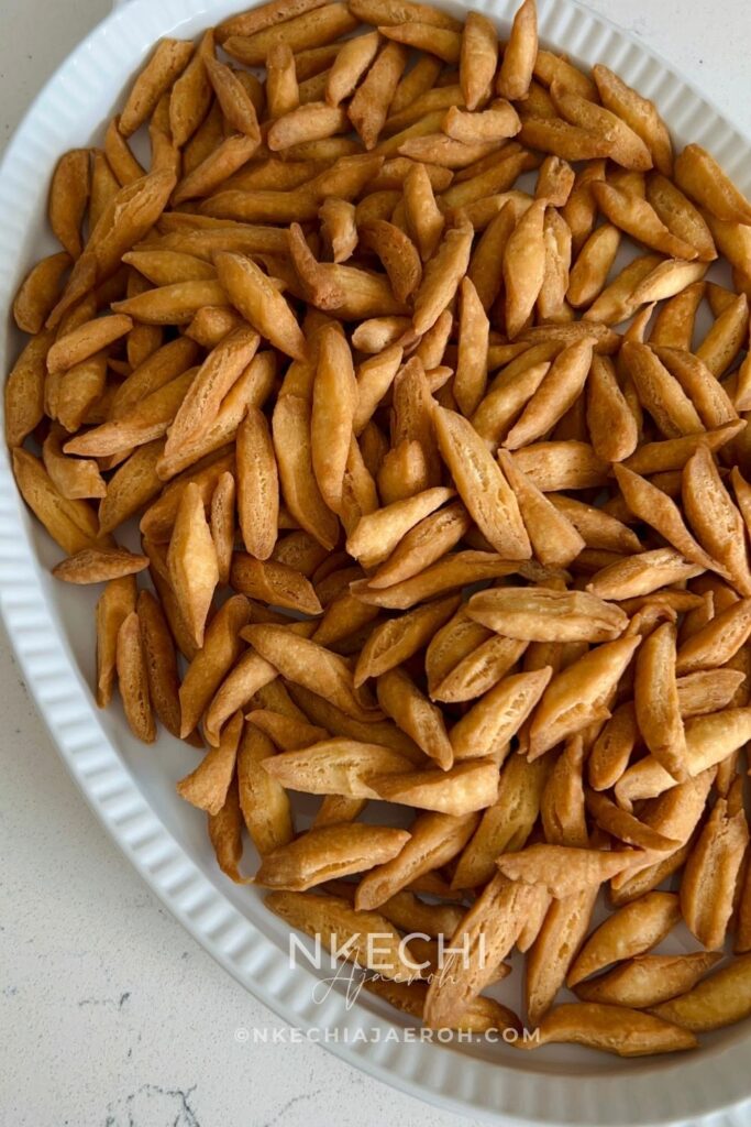 Nigerian chin chin is a popular West African snack known for its crunchy texture, buttery flavor, and lightly sweet taste. Made from a simple dough of flour, butter, sugar, eggs, and nutmeg, chin chin is rolled, cut into small pieces, and fried until golden and crisp.
This classic snack is a staple at holidays, birthdays, weddings, and family gatherings, and it’s just as common to find it sold as street food. Chin chin stays crunchy for days and is easy to make in large batches, which makes it perfect for sharing and gifting.