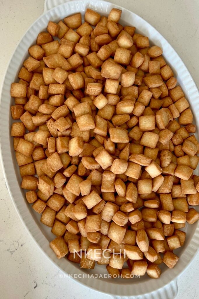 Nigerian chin chin is a popular West African snack known for its crunchy texture, buttery flavor, and lightly sweet taste. Made from a simple dough of flour, butter, sugar, eggs, and nutmeg, chin chin is rolled, cut into small pieces, and fried until golden and crisp. This classic snack is a staple at holidays, birthdays, weddings, and family gatherings, and it’s just as common to find it sold as street food. Chin chin stays crunchy for days and is easy to make in large batches, which makes it perfect for sharing and gifting.
Depending on how long it’s fried, chin chin can range from light golden to deep brown, with each shade offering a satisfying crunch. For many Nigerians and West Africans, chin chin isn’t just a snack — it’s a nostalgic treat that brings back memories of growing up and celebrating together.